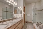 Large master bathroom with dual vanity sink, shower, and tub